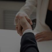 Female worker greeting business partner with handshake